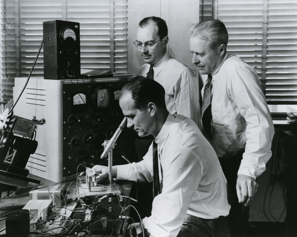 William Shockley (seated) with his Bell Labs colleagues John Bardeen (standing left) and Walter Brattain (standing right) in 1948. The trio later shared the Nobel Prize in physics for their pioneering work on the transistor. Credit: Bell Laboratories